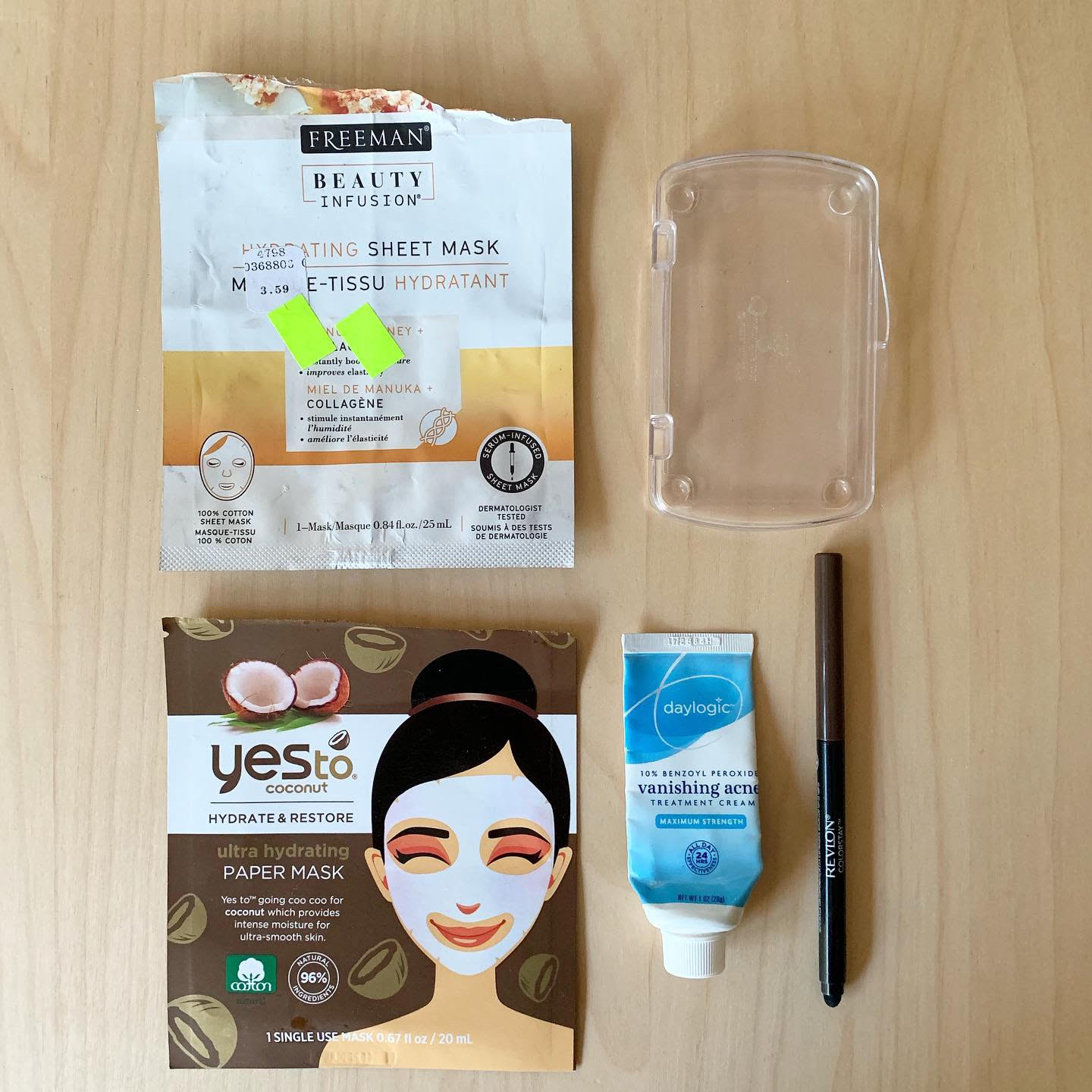 A photograph of empty beauty products - two face masks, a skincare product, an eyeliner, and a plastic box (representing a bar of soap).